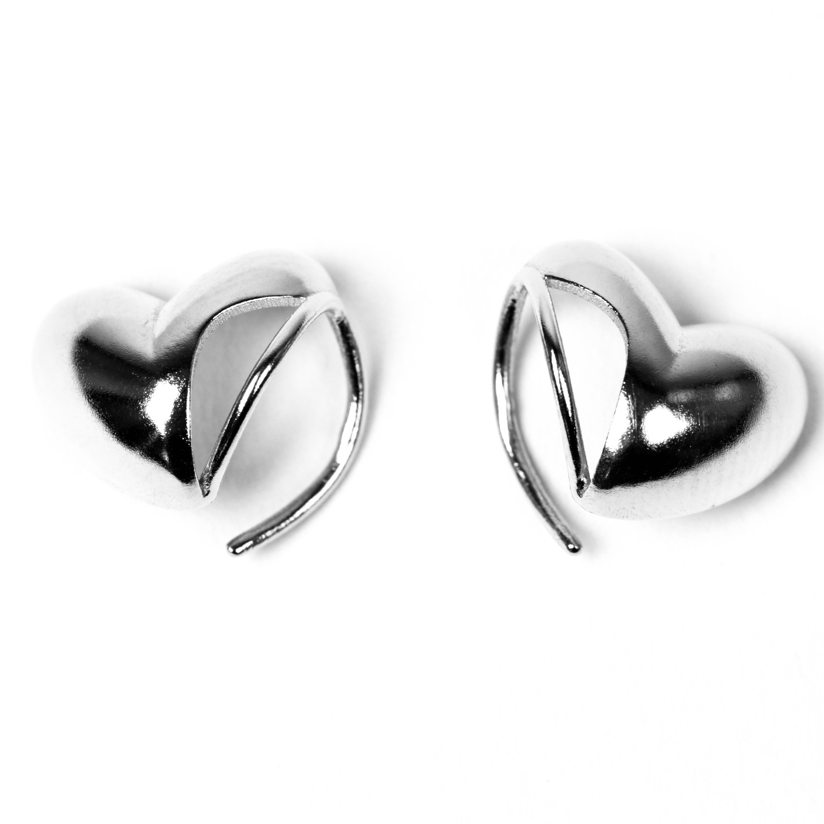 Heart-shaped white gold earrings on a white background