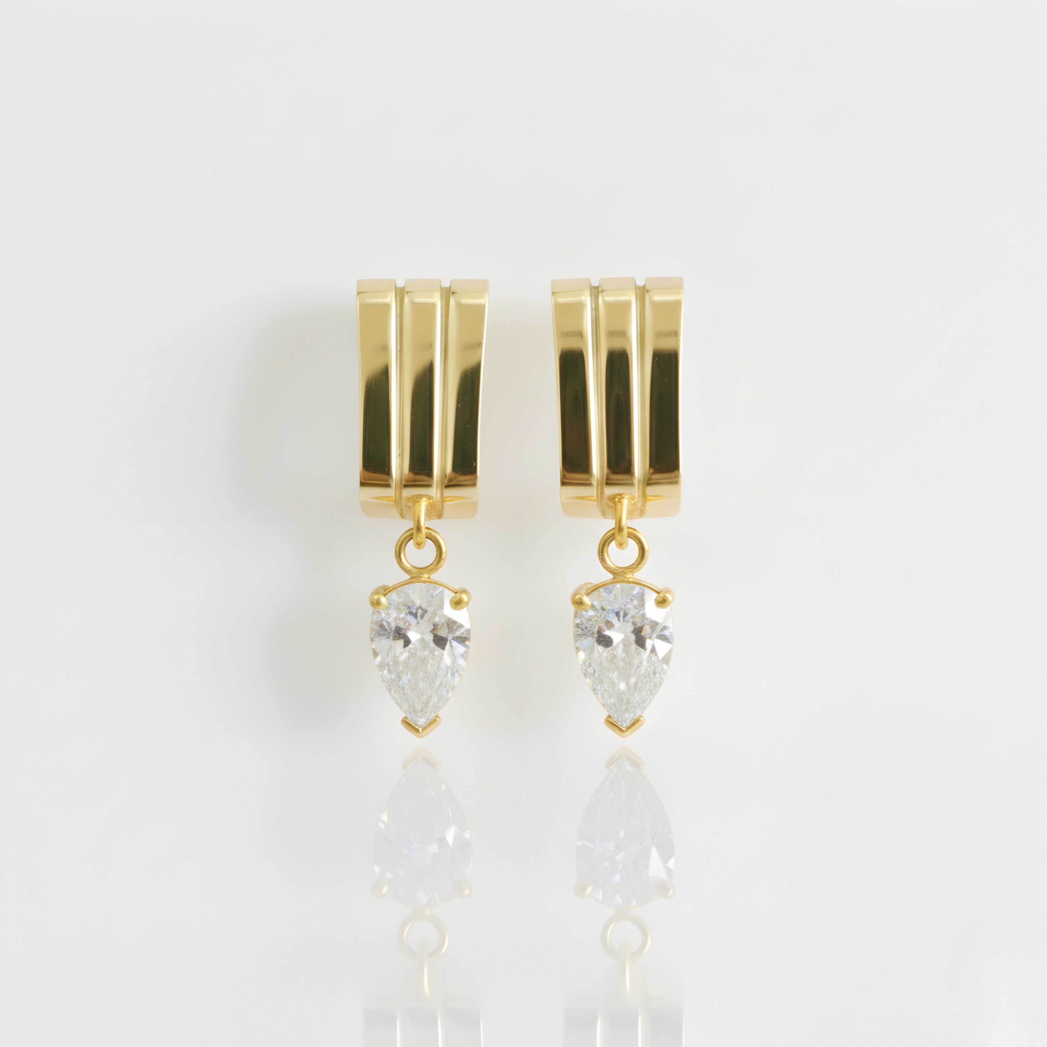 Gold earrings with diamond teardrop-shaped stones on a white background